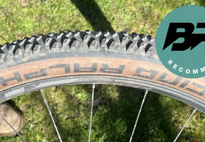 Close-up of a Schwalbe Racing Ralph tire on a bike wheel, ready for a review. The tan sidewall shows the "RALPH" branding.