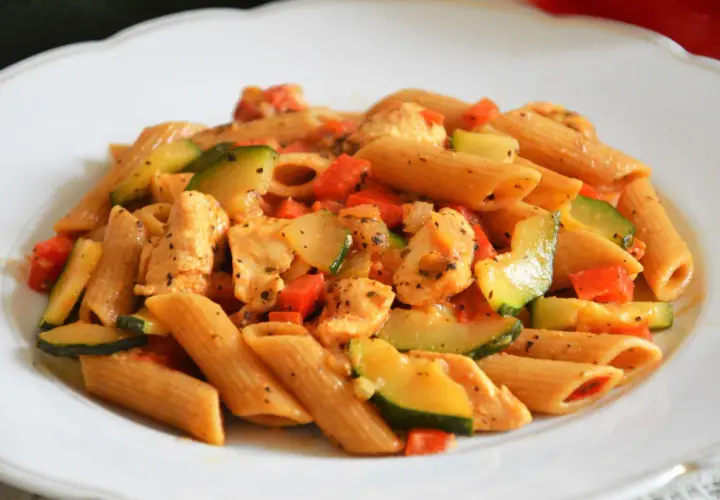 Penne z kurczakiem, cukinią i pomidorami w sosie. Pyszne dania z makaronem ryżowym i kurczakiem.
