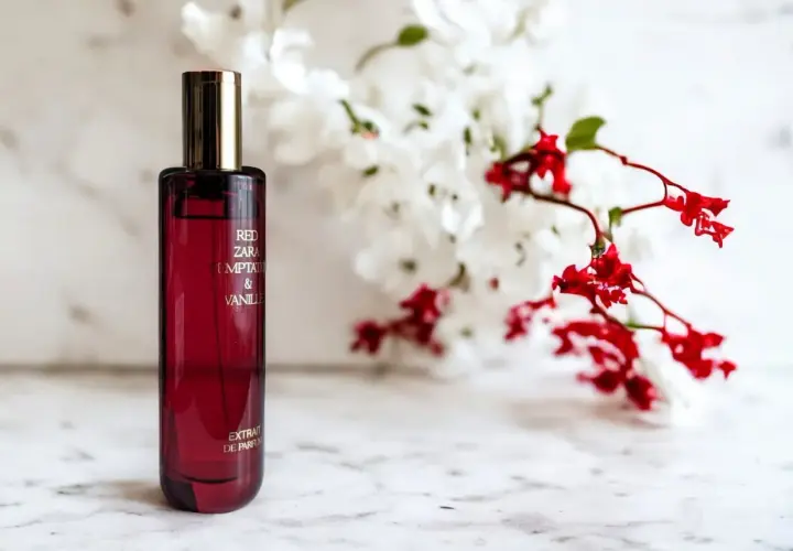 Elegancka butelka perfum Zara Red Temptation & Vanille, idealny odpowiednik dla miłośniczek zmysłowych zapachów, na tle delikatnych kwiatów.
