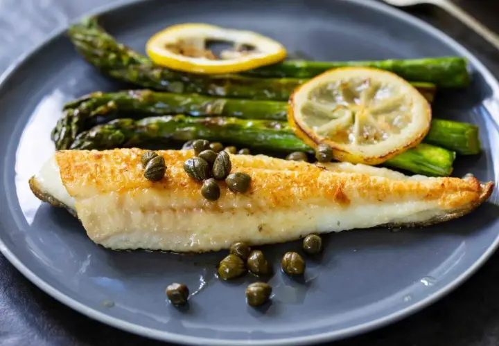Sogliola in friggitrice ad aria, dorata e succulenta, servita con asparagi croccanti, capperi e fette di limone.