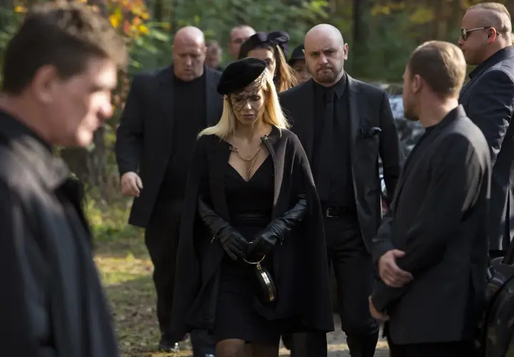 Kobieta w czerni, otoczona ochroniarzami, idzie na pogrzeb. Scena z filmu "Pitbull. Ostatni pies", obsada w żałobie.