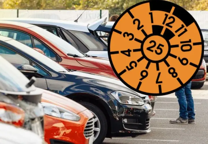 Rząd samochodów na parkingu z pomarańczową tarczą z numerami i cyfrą 25.