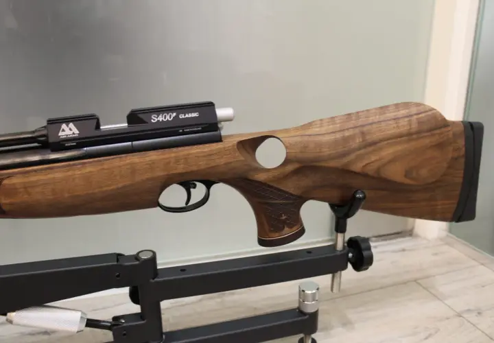 Elegancki karabin pneumatyczny Air Arms S510 z drewnianą osadą, prezentowany na statywie.
