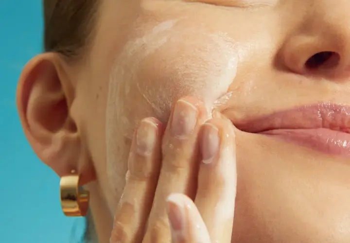 Mani delicate massaggiano schiuma sul viso, cercando sollievo per la pelle irritata.