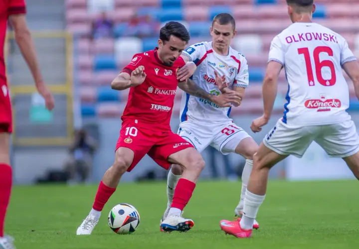 Piłkarze Widzewa Łódź i Górnika Zabrze walczą o piłkę. Czerwona koszulka z numerem 10 i biała z numerem 16.