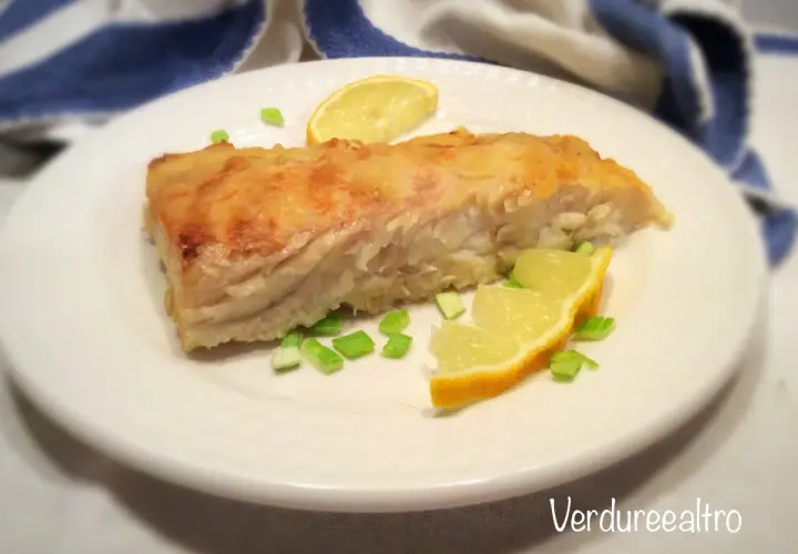 Un filetto di pesce persico cotto in padella, guarnito con spicchi di limone e erba cipollina. Perfetto per una ricetta pesce persico in padella al limone leggera e gustosa.