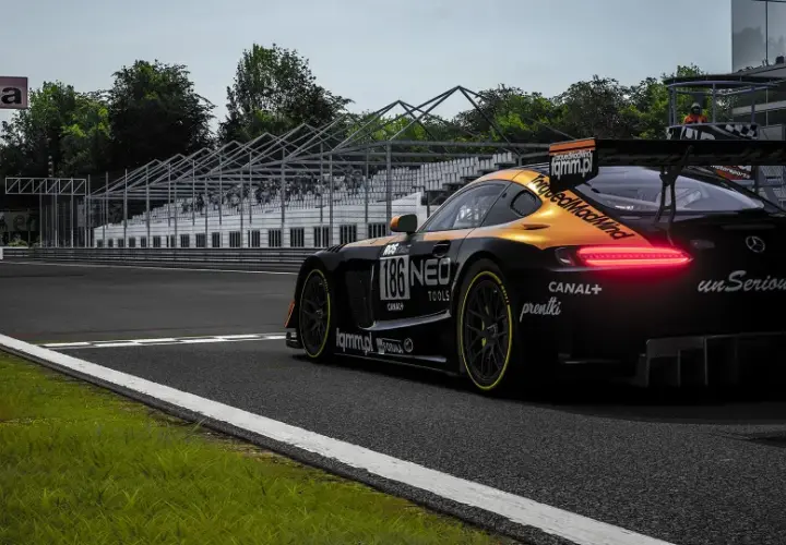 Czarny samochód wyścigowy z pomarańczowymi akcentami na torze. Widoczne logo "unSerious.pl", sugerujące polskie spolszczenie do Assetto Corsa.
