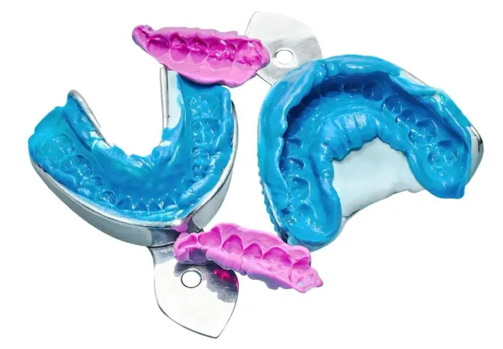 Impronta denti in silicone blu e rosa, dettagli precisi per un sorriso perfetto.