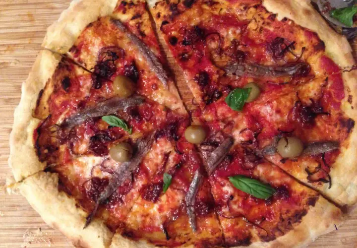 Pizza napolitana con anchoas, aceitunas y albahaca. Una delicia para disfrutar en cualquier momento.