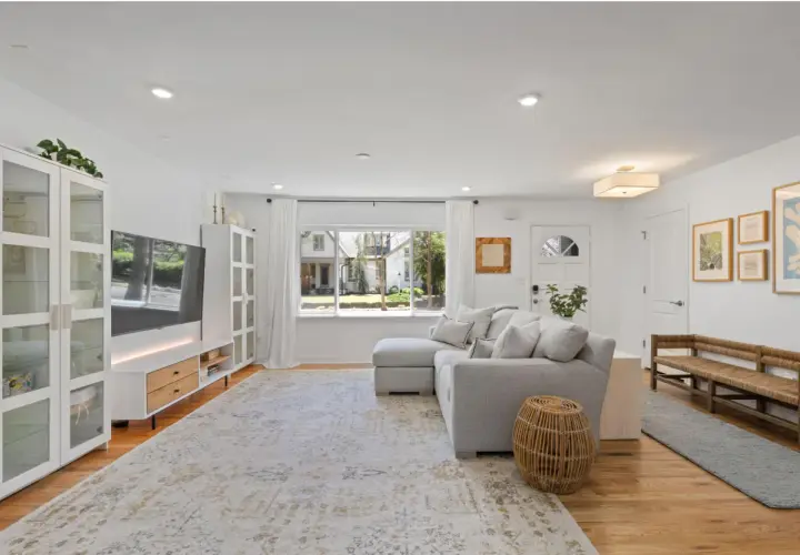 A bright living room with a sectional sofa, TV, and a large rug. This rug is made of polypropylene, so do polypropylene rugs get hot in the sun?