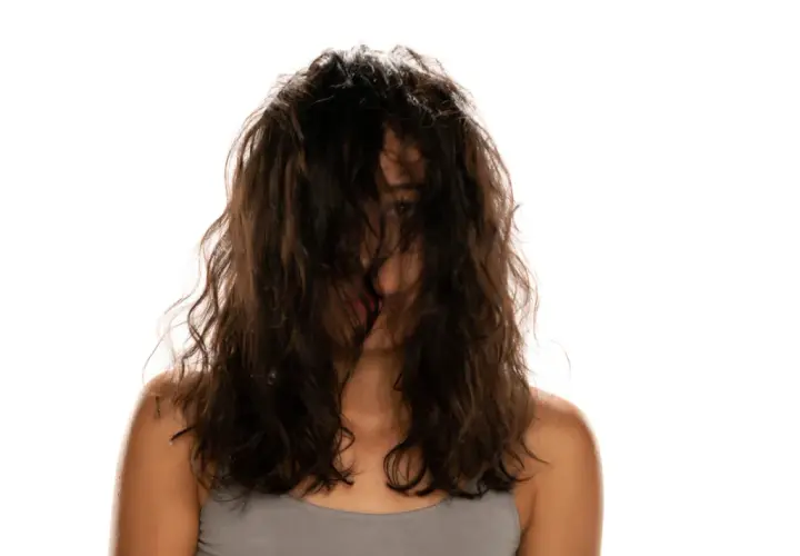 Frau mit dunklem, welligem Haar, das ihr Gesicht verdeckt. Ein Blick auf ihre Schultern und den Ansatz ihres Halses. Vielleicht ist dies das Ergebnis einer neuen locken routine.