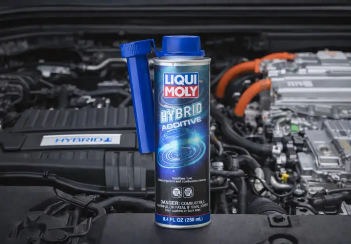 Dodatek do diesla Liqui Moly Hybrid Additive w puszce, na tle silnika hybrydowego. Dba o czystość układu paliwowego.
