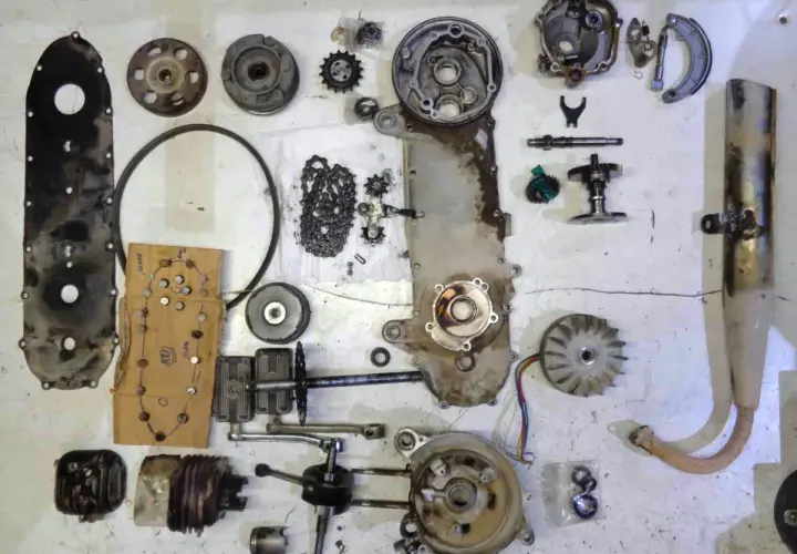 Despiece de una moto: carcasa, cadena, engranajes, cigüeñal, pistón, ventilador, escape y otras partes.