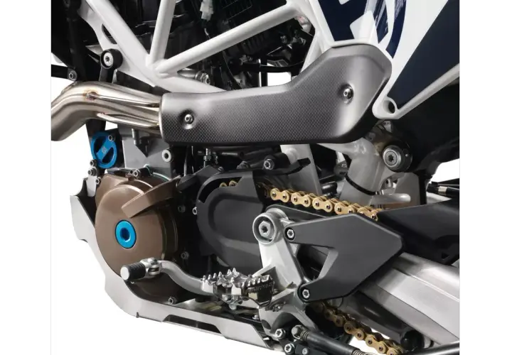 Szczegółowy widok silnika motocykla Husqvarna z widoczną złotą kasetą i elementami układu napędowego.