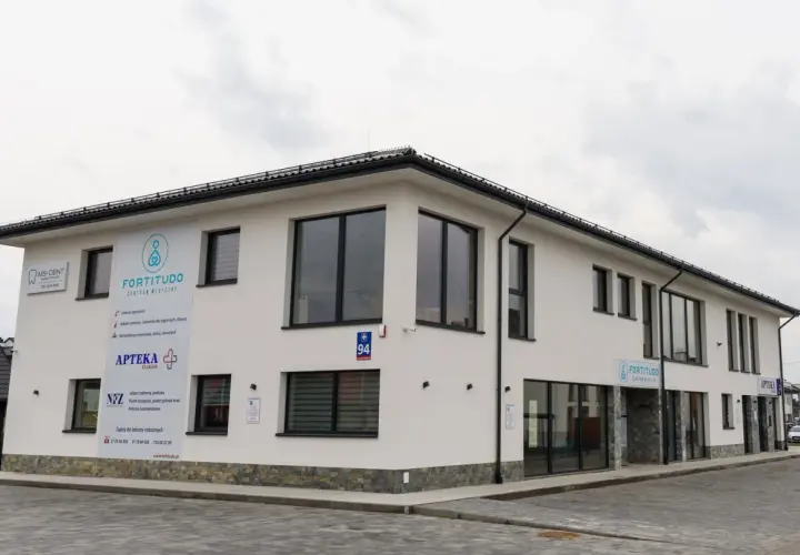 Nowoczesny budynek z szyldami "Fortitudo Centrum Medyczne", "MS-DENT" i "APTEKA".