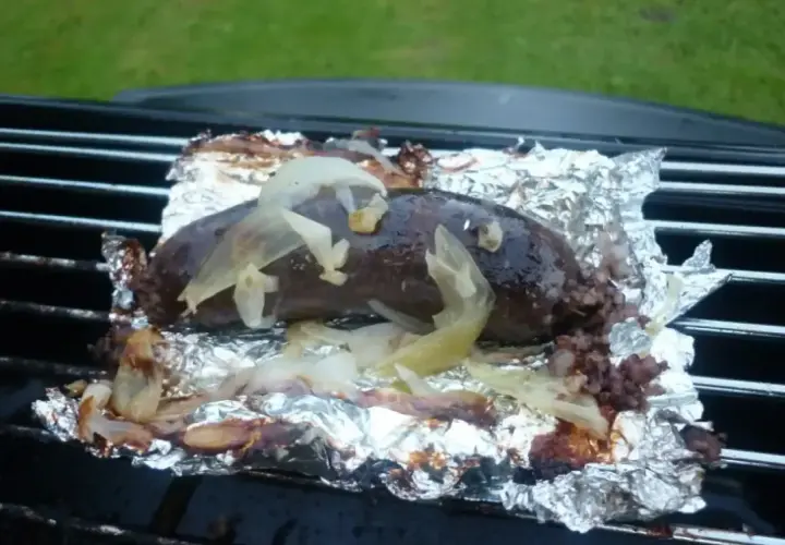 Kaszanka z grilla, soczysta i aromatyczna, pieczona na folii aluminiowej z cebulką. Idealna na letnie wieczory.