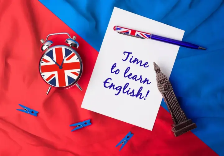 Budzik z flagą Wielkiej Brytanii, długopis i napis "Time to learn English!" na tle brytyjskich barw. Sebastian, czas na naukę!
