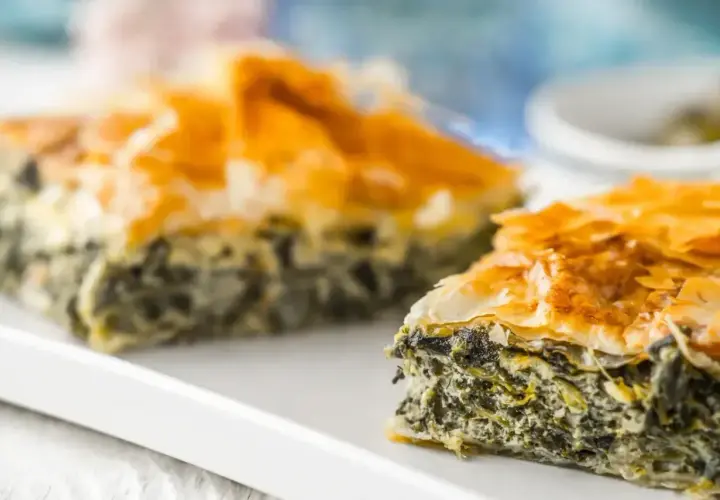 Chrupiąca spanakopita z warstw ciasta filo i zielonym nadzieniem ze szpinaku i sera.