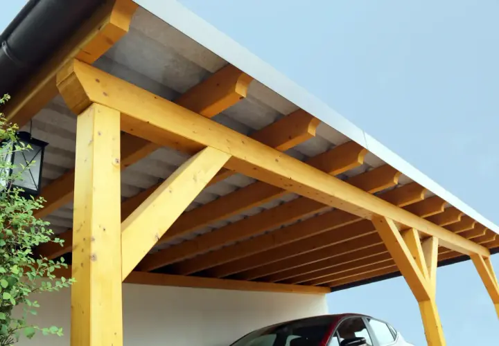 Detailansicht des Aufbaus eines Carport-Flachdachs mit sichtbaren Holzbalken und Dachpappe.