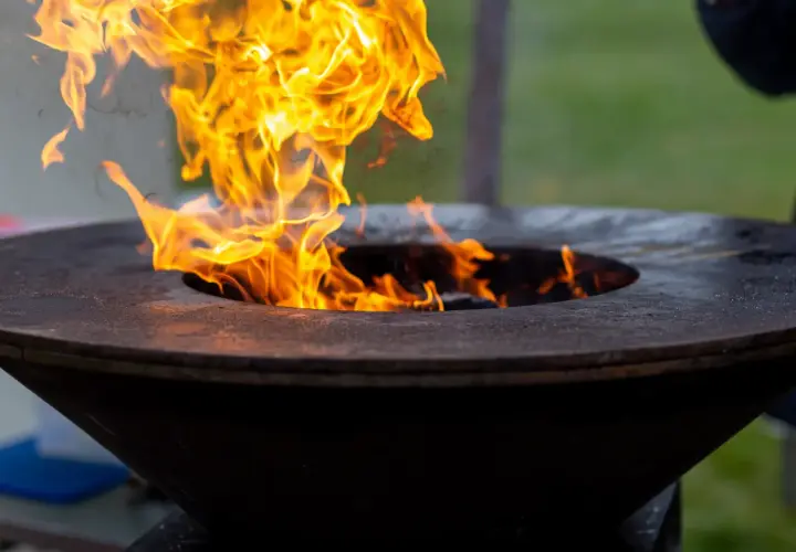 Flammes vives dans un brasero. Pensez à comment nettoyer un brasero après usage pour qu'il reste beau.