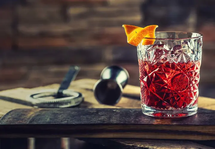 En klassisk negroni drink med apelsinskal, redo att avnjutas.