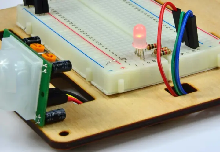 Czujnik ruchu PIR połączony z płytką styków i świecącą diodą LED. Ten kontaktron w oknie jest częścią projektu elektronicznego.