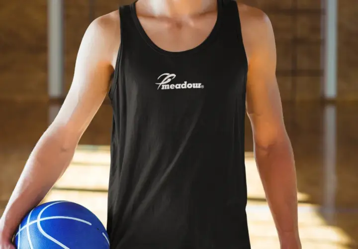 Gracz w czarnej koszulce z logo "Meadow" trzyma niebieską piłkę do koszykówki. Idealny do gry w koszykówkę 3x3, zasady tej dynamicznej odmiany sportu są proste i angażujące.