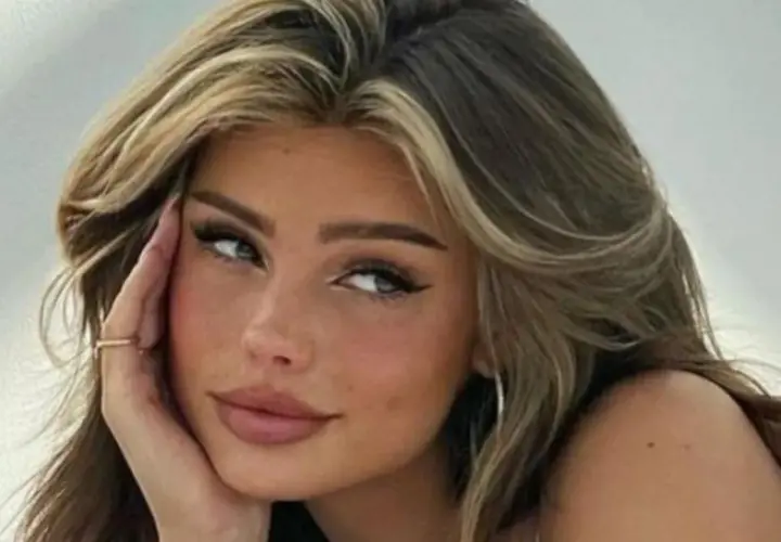 Primer plano de una joven con cabello castaño y reflejos rubios, con sus baby hairs peinados hacia atrás.