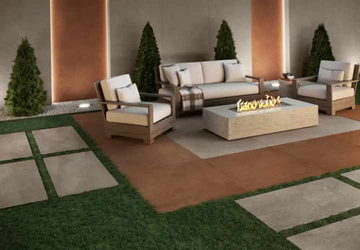 Elegante soggiorno esterno con divano, poltrone e tavolino con fuoco. Il pavimento per balcone in gres porcellanato effetto pietra crea un'atmosfera accogliente.