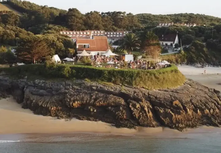 Evento en la playa madre Cantabria, con gente disfrutando de la terraza y el ambiente festivo, quizás antes de unos conciertos.