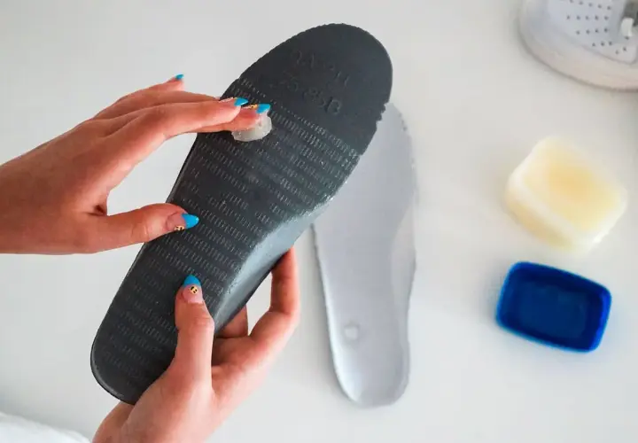 Applying balm to an insole to stop slides from squeaking.