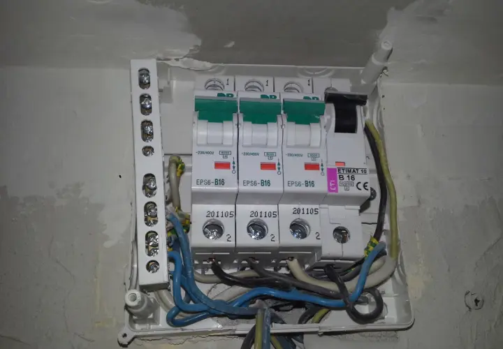 Widok z bliska na skrzynkę z bezpiecznikami i przewodami elektrycznymi.