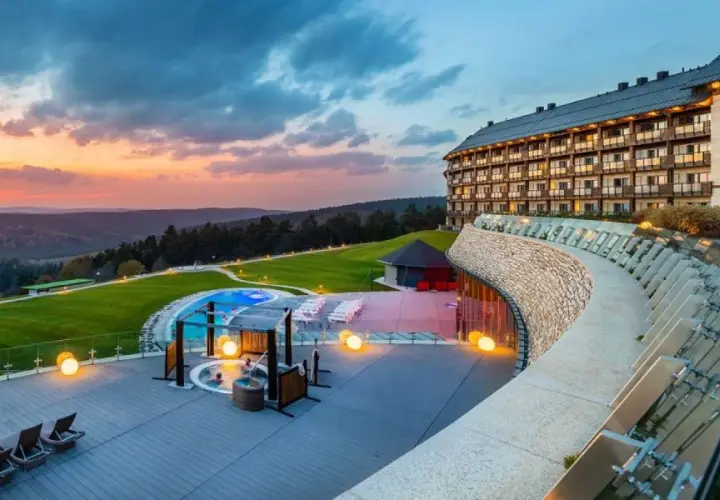 Luksusowy hotel z basenem i jacuzzi na tarasie, otoczony malowniczymi wzgórzami. To jeden z najlepszych hoteli w Polsce, idealny na relaks.