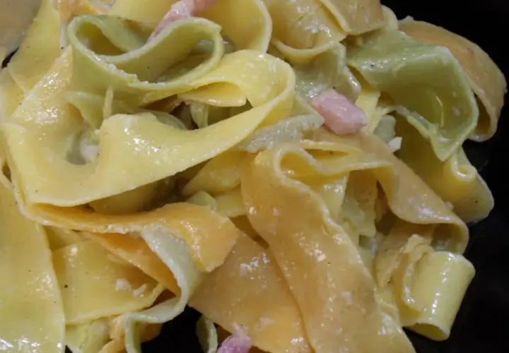 Pâtes larges, jaunes et vertes, nappées d'une sauce crémeuse et parsemées de lardons. Un délice de sauce carbonara.