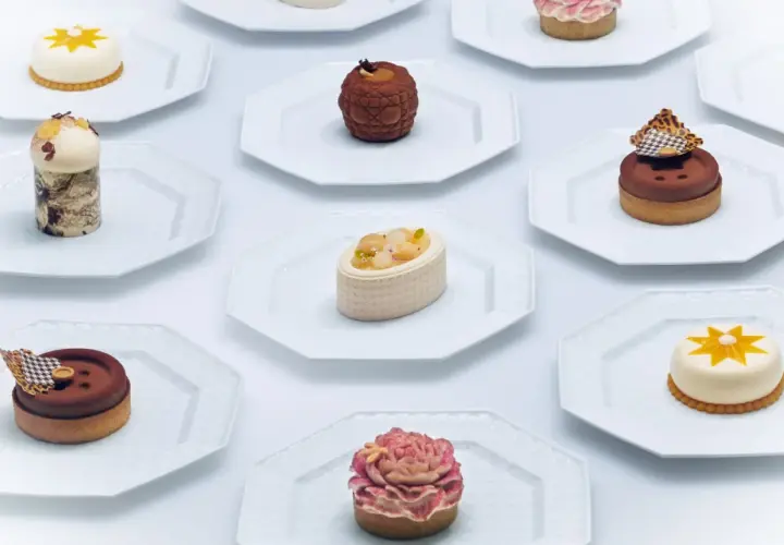 Collection de petits gâteaux raffinés, un véritable produit de luxe alimentaire, présentés sur des assiettes blanches.