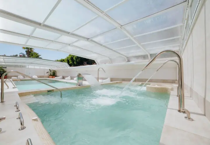 Piscinas termales cubiertas con chorros de agua y cascadas, perfectas para relajarse en el camping Alannia Guardamar.