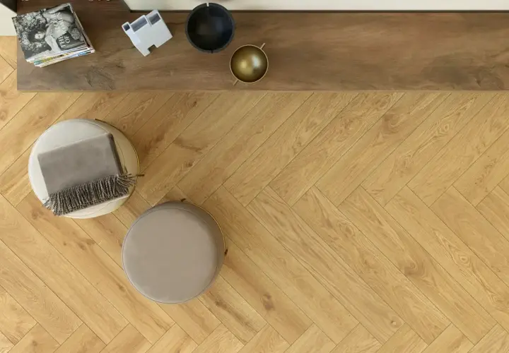 Posa pavimento gres effetto legno a spina di pesce, con pouf e coperta.