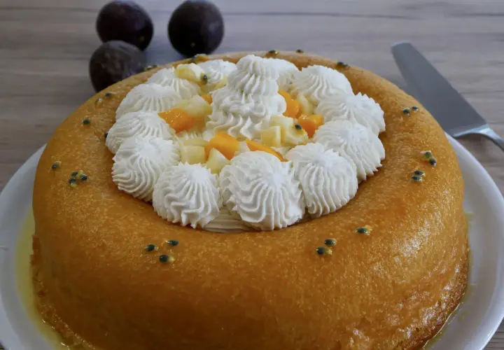 Un baba au rhum doré, garni de crème fouettée, fruits exotiques et graines de fruits de la passion. Un délice !