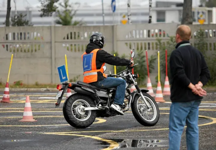 Nauka jazdy na motorowerze na placu manewrowym. Czy to szansa na prawo jazdy AM za darmo? Instruktor obserwuje kursanta.