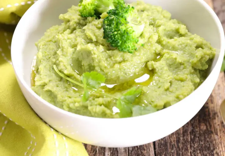 Un bol de purée de brocolis onctueuse, garnie de fleurettes de brocolis et d'un filet d'huile d'olive. Une touche de verdure pour un plat sain.