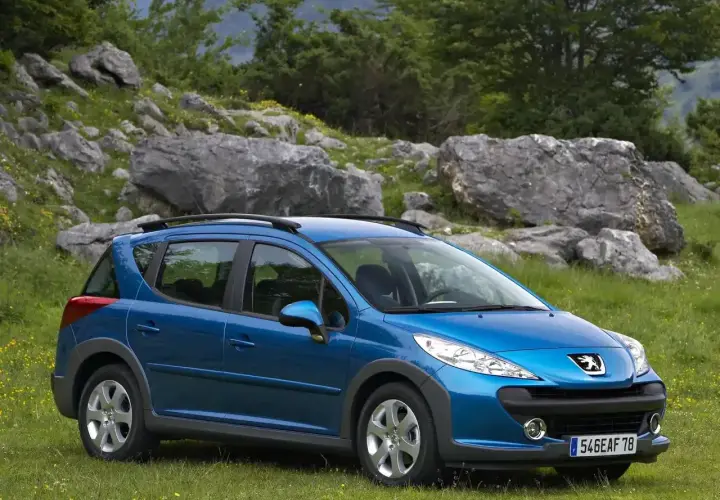 Niebieski Peugeot 207 SW na tle górskiego krajobrazu. Wiele osób chwali ten model w swoich **Peugeot 207 opinie**.