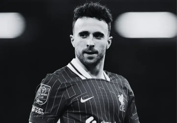 Diogo Jota, piłkarz Liverpoolu, w czarno-białym ujęciu. Skupiony wzrok, charakterystyczna fryzura.