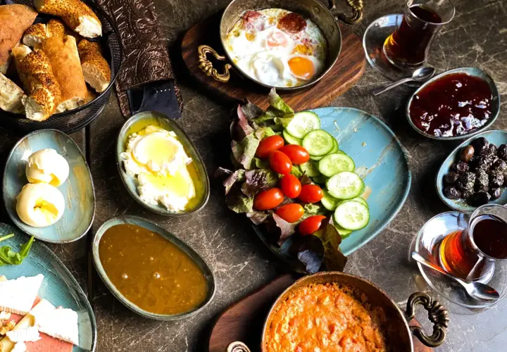 Pyszne śniadanie w jednej z najlepszych restauracji Warszawa: jajka sadzone, sery, pieczywo, oliwki, dżem i herbata.