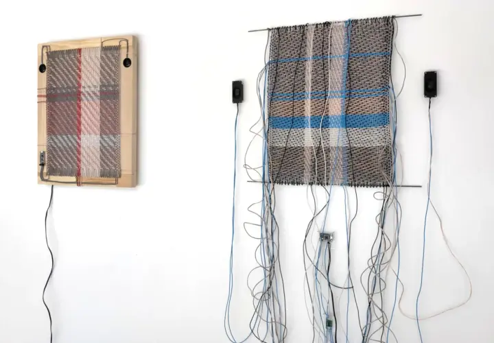 Deux œuvres d'art de tissage dessin, ornées de fils et de câbles, sont accrochées à un mur blanc.