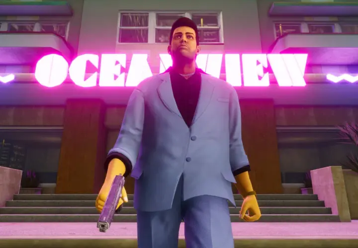 Tommy Vercetti z GTA Vice City Definitive Edition stoi przed neonowym napisem "OCEAN VIEW", trzymając pistolet.