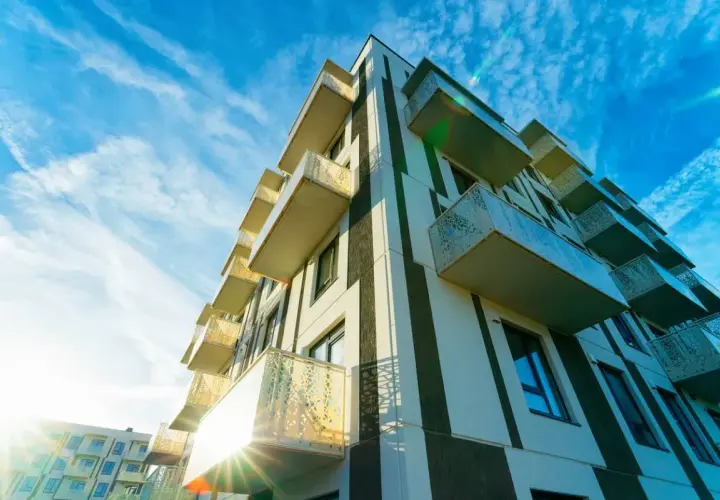 Immeuble moderne aux balcons saillants, sous un ciel bleu zébré de nuages. Un projet qui pourrait faire l'objet d'un recours pour perte d'ensoleillement.