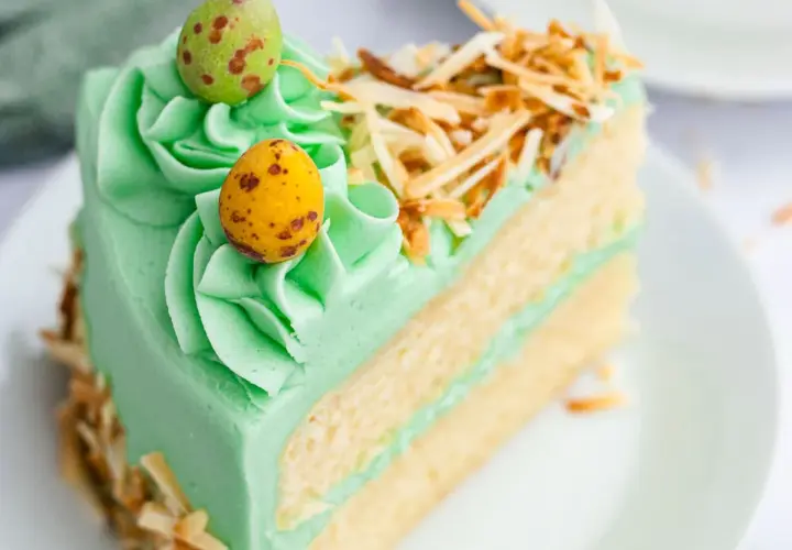 Rebanada de pastel verde menta con glaseado, decorada con huevos de pascua y coco tostado. ¡Ideas de pasteles de Pascua!