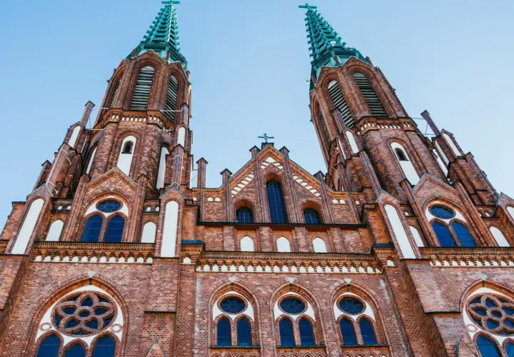Dwie wieże ceglanego kościoła, z zielonymi iglicami i ozdobnymi rozetami, to jedne z najpiękniejszych kościołów w Polsce.