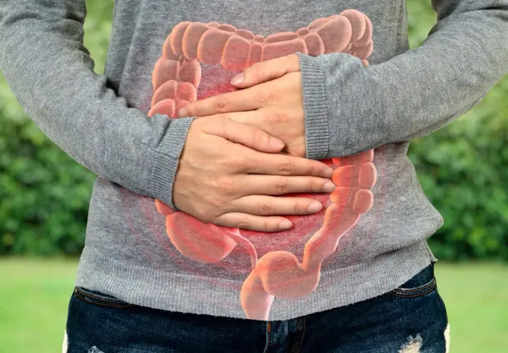 Personne tenant son ventre, avec une image superposée d'intestins rouges. Selles liquides comme de l'eau que faire ?