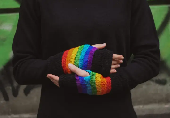 Tęczowe mitenki dodają koloru czarnemu swetrowi.